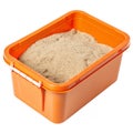 Orange plastic container with sand isolated on white background Royalty Free Stock Photo