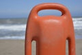 Orange plastic life preserver in the foreground with the sea in the background. Royalty Free Stock Photo