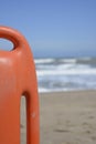 Orange plastic lifebelt in the foreground with the sea in the background Royalty Free Stock Photo