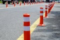 Orange plastic poles on the road to separate lanes stand in row