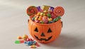 Orange plastic pumpkin bucket filled with assorted halloween candy Royalty Free Stock Photo