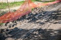 Orange plastic safety net or barrier on the street to protect excavating construction site close up Royalty Free Stock Photo