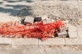 Orange plastic safety net or barrier on the street to protect people for step in to the damaged sidewalk with hole Royalty Free Stock Photo