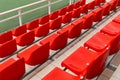 Orange plastic spectator seats in diagonal view, sport venue equipment