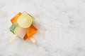 Orange popsicle and lime popsicle on marble table Royalty Free Stock Photo