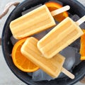 Orange popsicles in a rustic ice filled tin pail Royalty Free Stock Photo