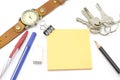 Orange post it with keys watch and bulldog clip and black pencil