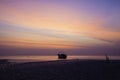 Orange predawn skies and a stranded lone boat Royalty Free Stock Photo