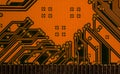 Orange printed circuit board with scratched golden connectors, closeup detail Royalty Free Stock Photo