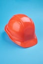 Orange protective helmet and safety glasses near it on a bright blue background. protective workwear and construction Royalty Free Stock Photo