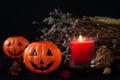 Orange pumpkin as a head with carved eyes and a smile with burning candles on a black background with a garland to the Halloween Royalty Free Stock Photo