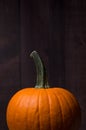 Orange pumpkin with dark wood background