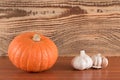 Orange pumpkin and garlic on a wooden table