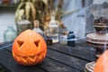 Orange pumpkin for halloween, jack-o-lantern with scary carved eyes, mouth.Candles, old lamp, spiderweb on wooden table near barn Royalty Free Stock Photo