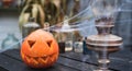 Orange pumpkin for halloween, jack-o-lantern with scary carved eyes, mouth.Candles, old lamp, spiderweb on wooden table near barn Royalty Free Stock Photo