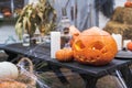 Orange pumpkin for halloween, jack-o-lantern with scary carved eyes, mouth.Candles, old lamp, spiderweb on wooden table Royalty Free Stock Photo