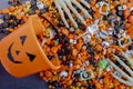 Halloween candy spilling out of orange pumpkin bucket