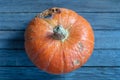 Orange pumpkin with rotten side on wooden table Royalty Free Stock Photo