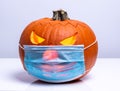 Orange pumpkin is wearing protective medical mask, autumn second wave of coronavirus infection, halloween and covid-19 concept Royalty Free Stock Photo