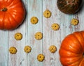 Orange pumpkins and tasty pumpkin cookies on a light blue wooden background. Royalty Free Stock Photo