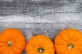 Orange pumpkins on weathered blackwash wood textured background