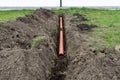 Orange PVC pipe buried in the ground connected to the gutter, used to connect to the drainage pipe.