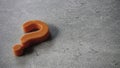 Orange question mark symbol on gray surface Royalty Free Stock Photo