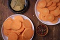 Orange raw sweet potatoes, yam slices on plates, burlap, wooden rustic table, allspice pepper peas, bay leaves. Farm harvest, Royalty Free Stock Photo