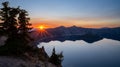 Orange Rays from Sunset Behind Mountains Over Crater Lake Royalty Free Stock Photo