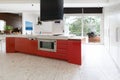 Orange red kitchen cabinets in island bench in modern luxury Australian home