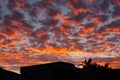 Orange and red sunset clouds over house. Royalty Free Stock Photo