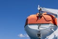 Orange rescue motor boat with which each passenger ferry is equipped, background with clear blue summer morning sky