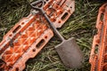 Orange rescue sand tracks and shovel on grass. Royalty Free Stock Photo