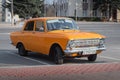 Orange retro car Moskvich-412 of the Izhevsk Automobile Plant on the city street.