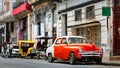 Orange retro car taxi and people passers-by in the old center of Havana. Royalty Free Stock Photo