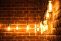 Orange retro lamps hanging on a dark black brick wall background Royalty Free Stock Photo