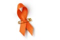 Orange ribbon with safety pin on white background - Concept of leukemia awareness, kidney cancer association, multiple sclerosis