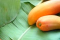 orange ripe papaya on green banana leaf background have space