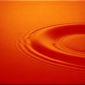 Orange ripples concentric circles spreading across liquid surface for creative backdrop Royalty Free Stock Photo