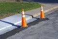 Orange road construction safety traffic cones during road repair construction maintenance work at sidewalk curb city Royalty Free Stock Photo