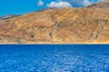 Orange rocky hill and deep blue ocean Royalty Free Stock Photo