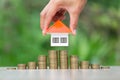 Orange roof house Held by investors Will put on a pile of coins.Concept of planning for saving money to buy a house, mortgage Royalty Free Stock Photo