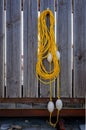 orange rope with buoys hanging on a wooden fence. Rescue equipment for emergency on water. Royalty Free Stock Photo