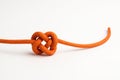 Orange rope with a knot on a light background. Royalty Free Stock Photo
