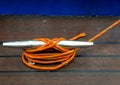 Orange rope tied to a metal cleat on a wooden boat deck Royalty Free Stock Photo
