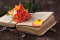 Orange rose with old book and glasses Royalty Free Stock Photo