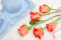 Orange roses and blue bodice with lace on white fur. Fashionable concept. Top view, close-up