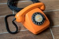 Orange retro telephone on wooden background Royalty Free Stock Photo