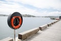 Orange round Life buoy at the waterfront. Royalty Free Stock Photo