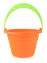 Orange rubber or plastic baby bucket with a green handle on a white background. Bucket for playing in the sandbox or Royalty Free Stock Photo